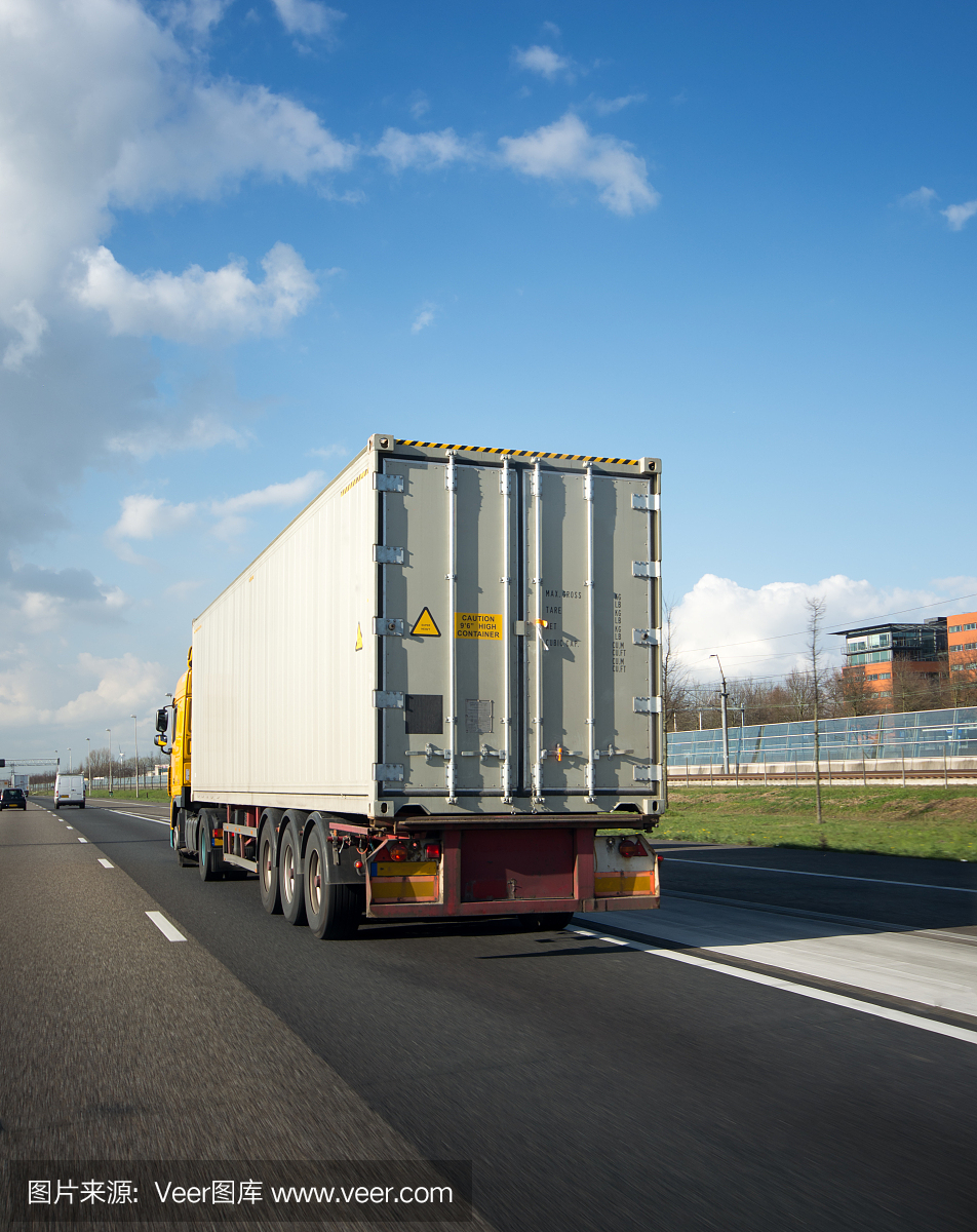 在高速公路上经过一辆集装箱卡车